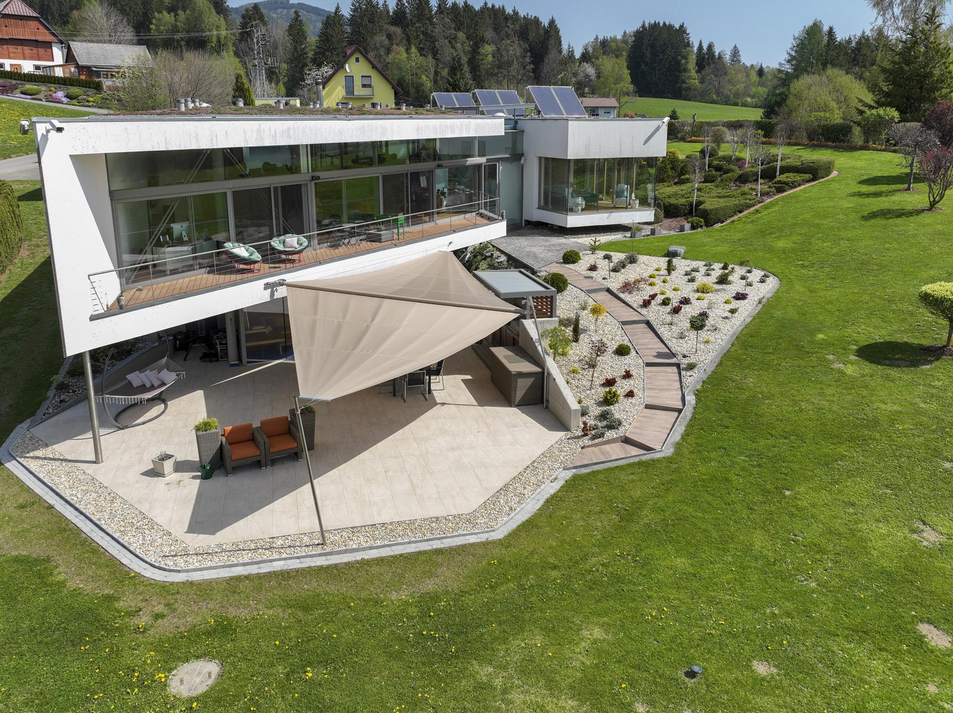 Blick auf das ausgefahrene Doppel Dreieck Sonnensegel leicht schräg