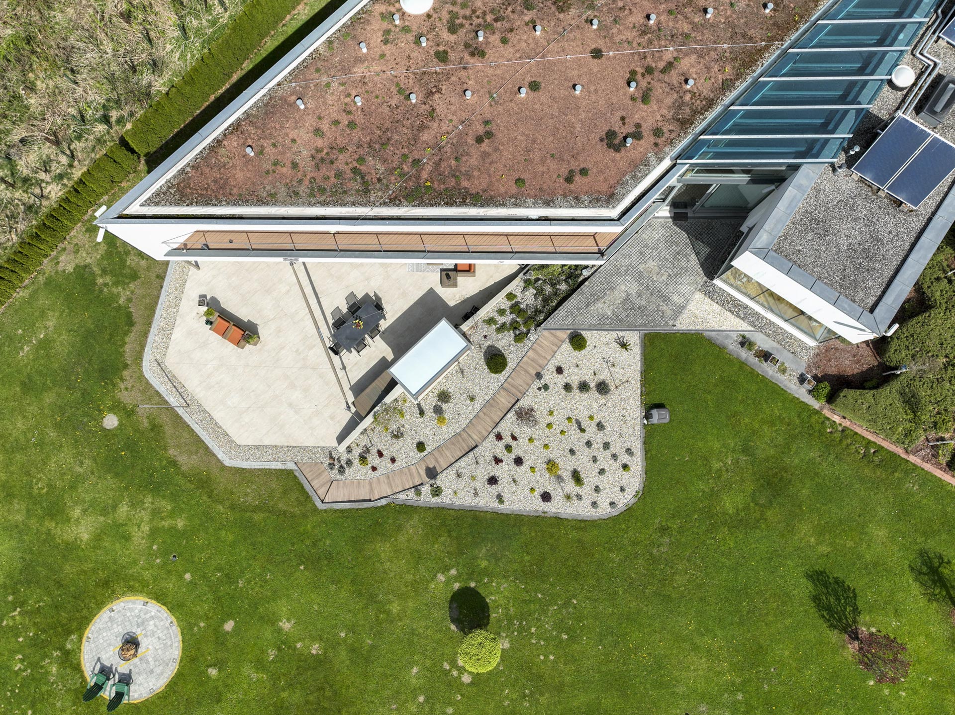 Das eingefahrene beige Doppel Dreieck Sonnensegel seitlich zum Rauten förmigen Haus