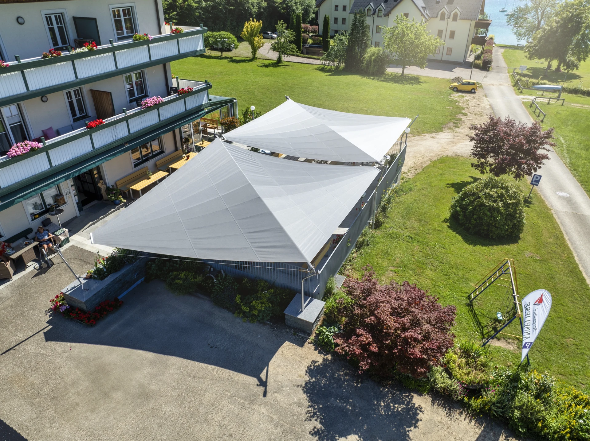 zwei Doppeldreieck Segel als Gastro Sonnenschutz freistehend im Gastgarten