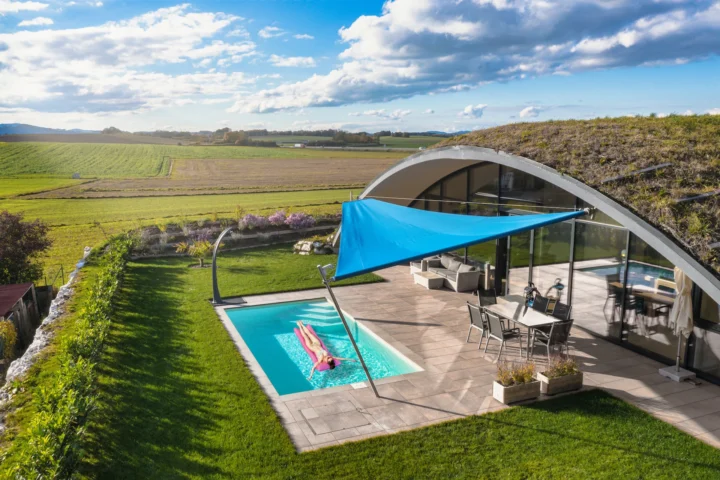 Blaues Dreieck-Sonnensegel von LET über dem Pool einer modernen Hügelvilla