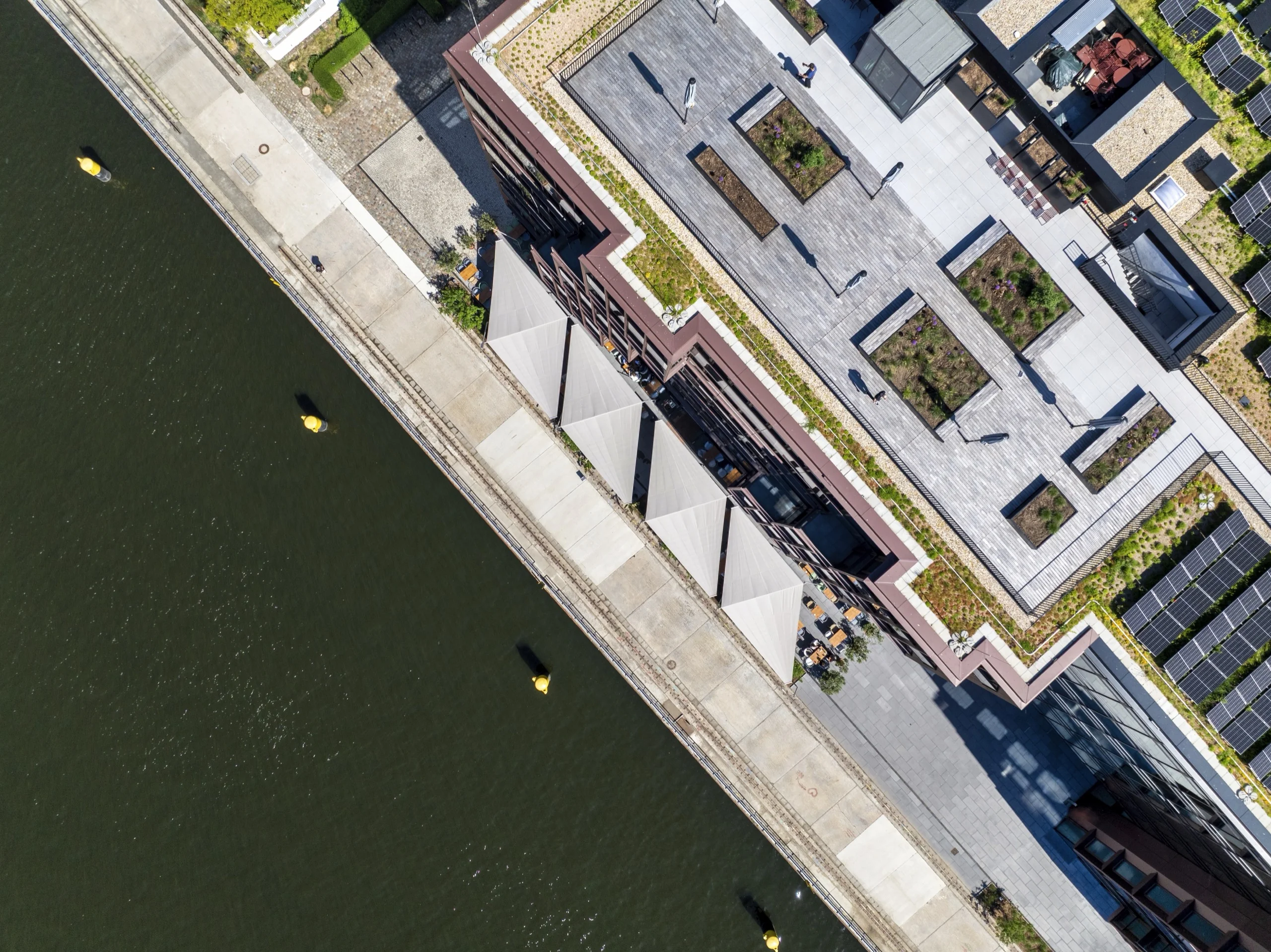 Modernes Gebäude mit Sonnensegel-Terrasse des Of Eden an der Spree, Drohnen-Topshot
