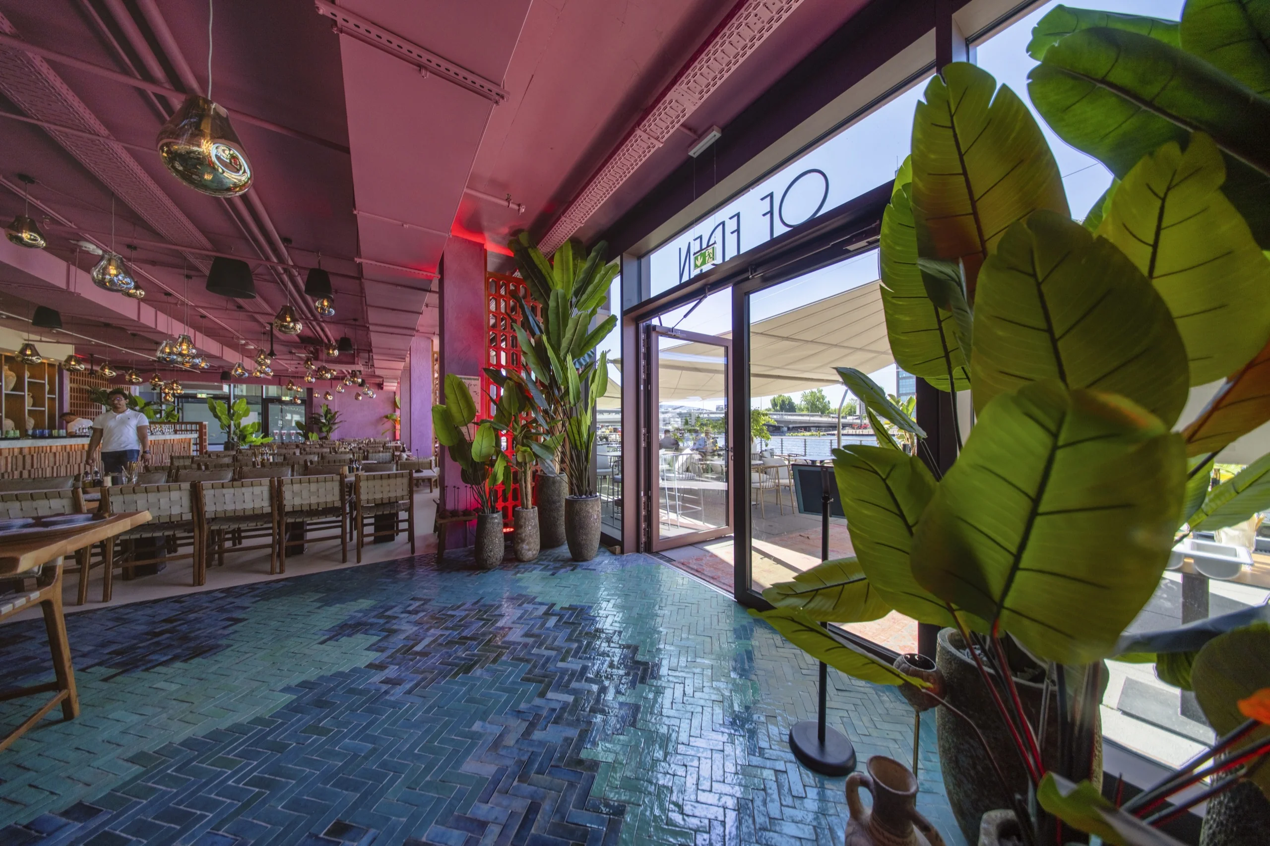 Vom Restaurantinneren durch die Glasfront auf das Sonnensegel des Of Eden Berlin