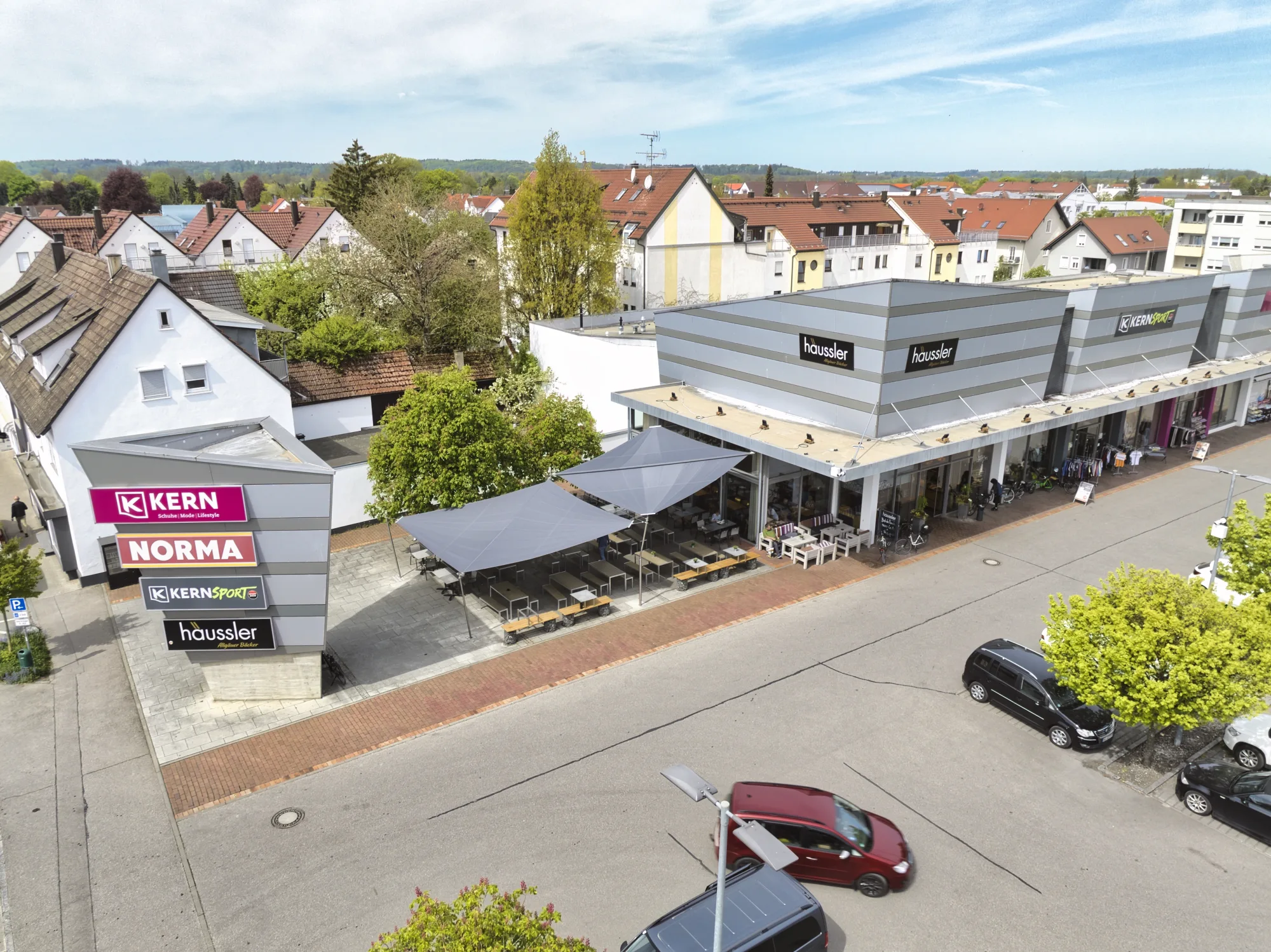 Luftbild der Filiale von Backhaus Häussler in Illertissen mit aufgerolltem Sonnensegel über der Gastro-Terrasse