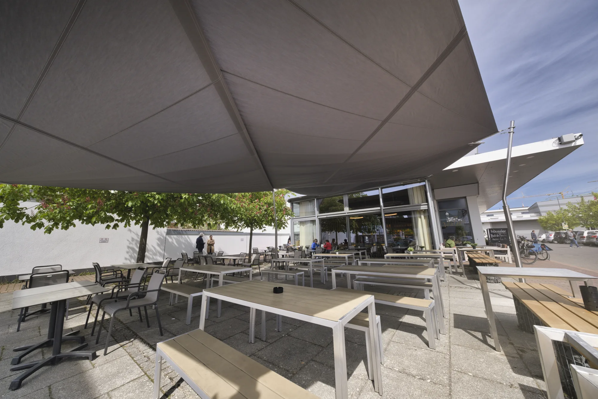 Beschattete Gastro-Terrasse unter dem aufrollbaren Sonnensegel von Backhaus Häussler