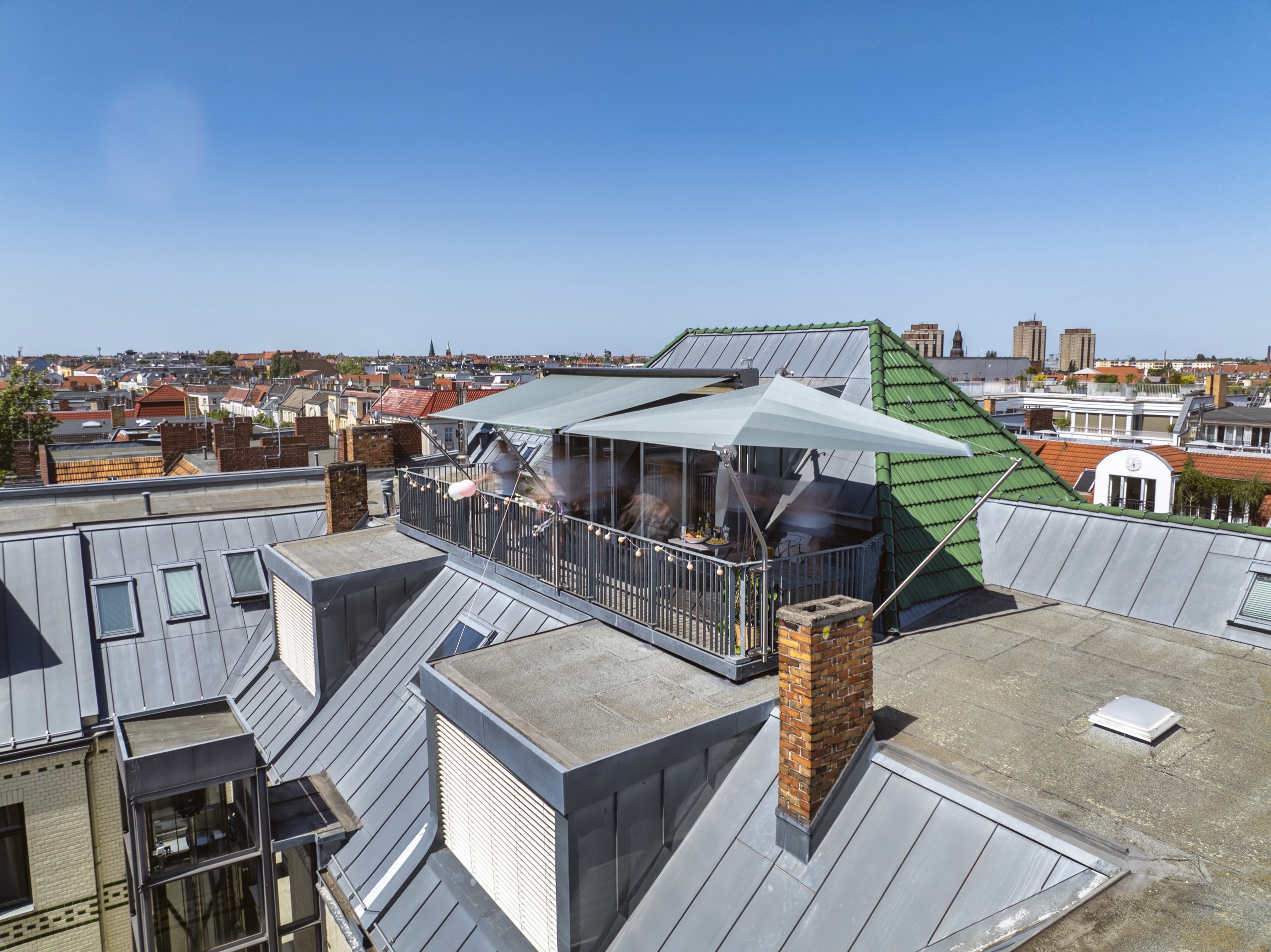 Dachterrasse im sechsten Stock mitten in Berlin mit Sonnensegel über den Dächern