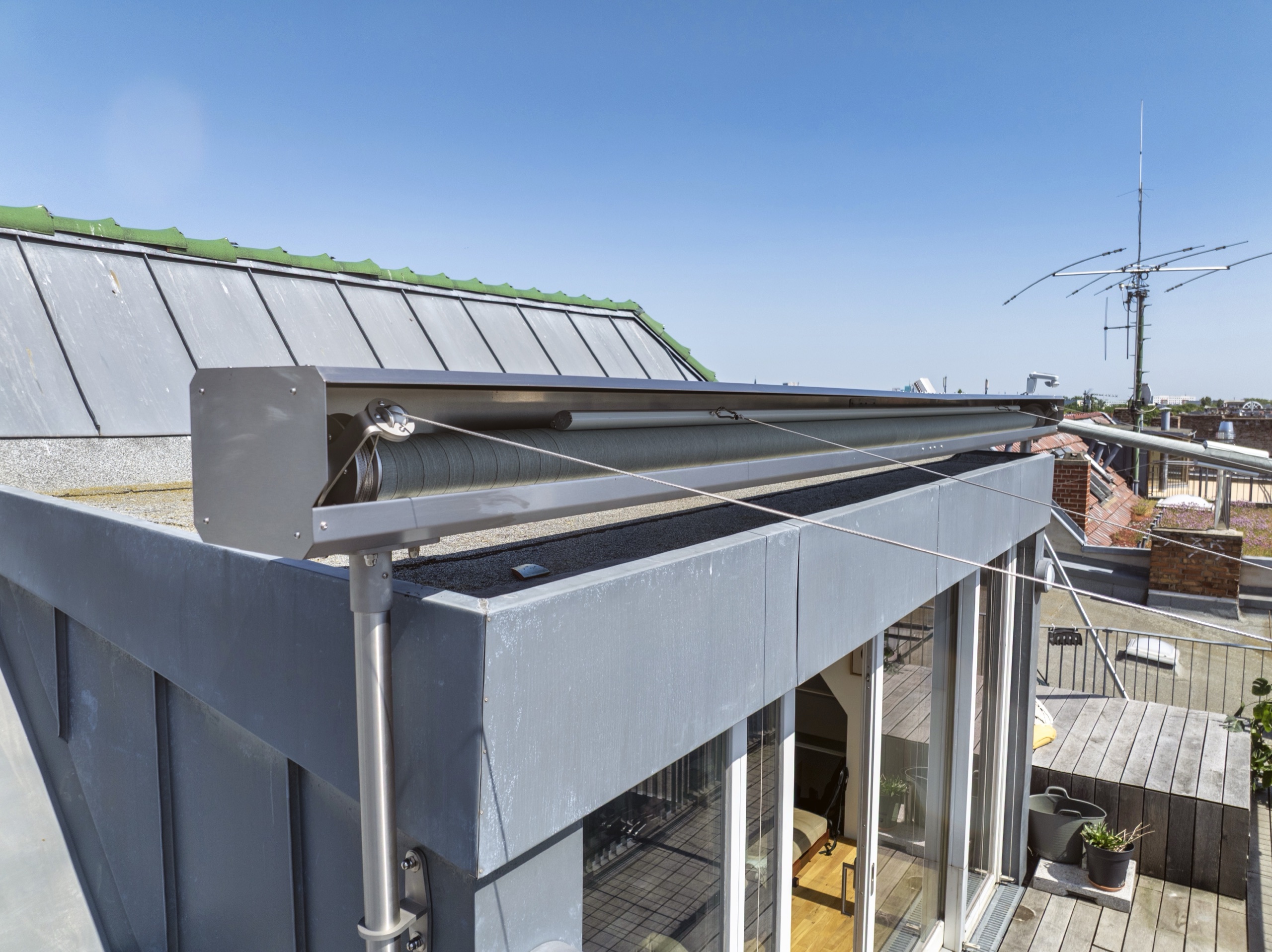 Trapez-Sonnensegel im nichtrostenden Aluminium-Wellenkasten über der Dachterrasse
