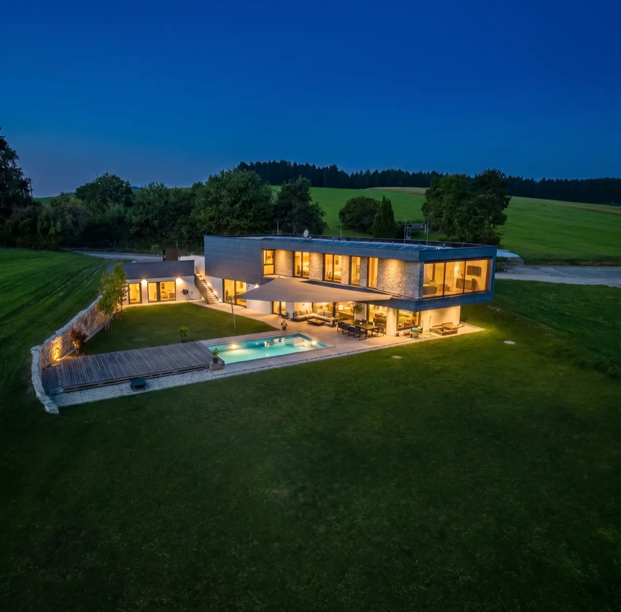 Dreieck-Sonnensegel von LET über Pool und Terrasse bei Nacht