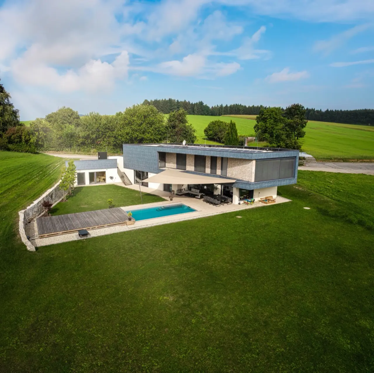 Dreieck-Sonnensegel von LET über Pool und Terrasse bei Tag