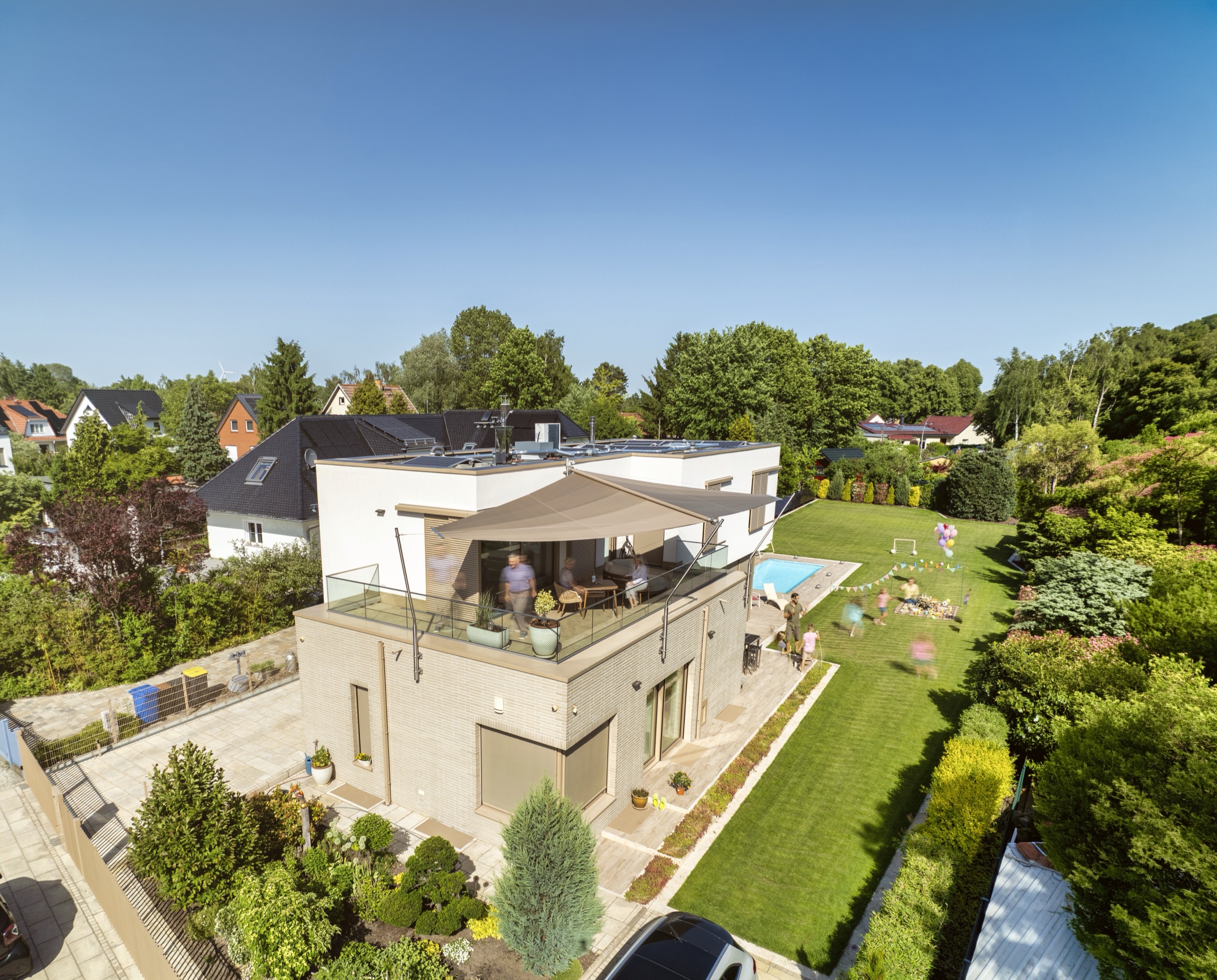 Sonnensegel über der Dachterrasse eines modernen Hauses in Berlin, Luftaufnahme mit Garten und Pool