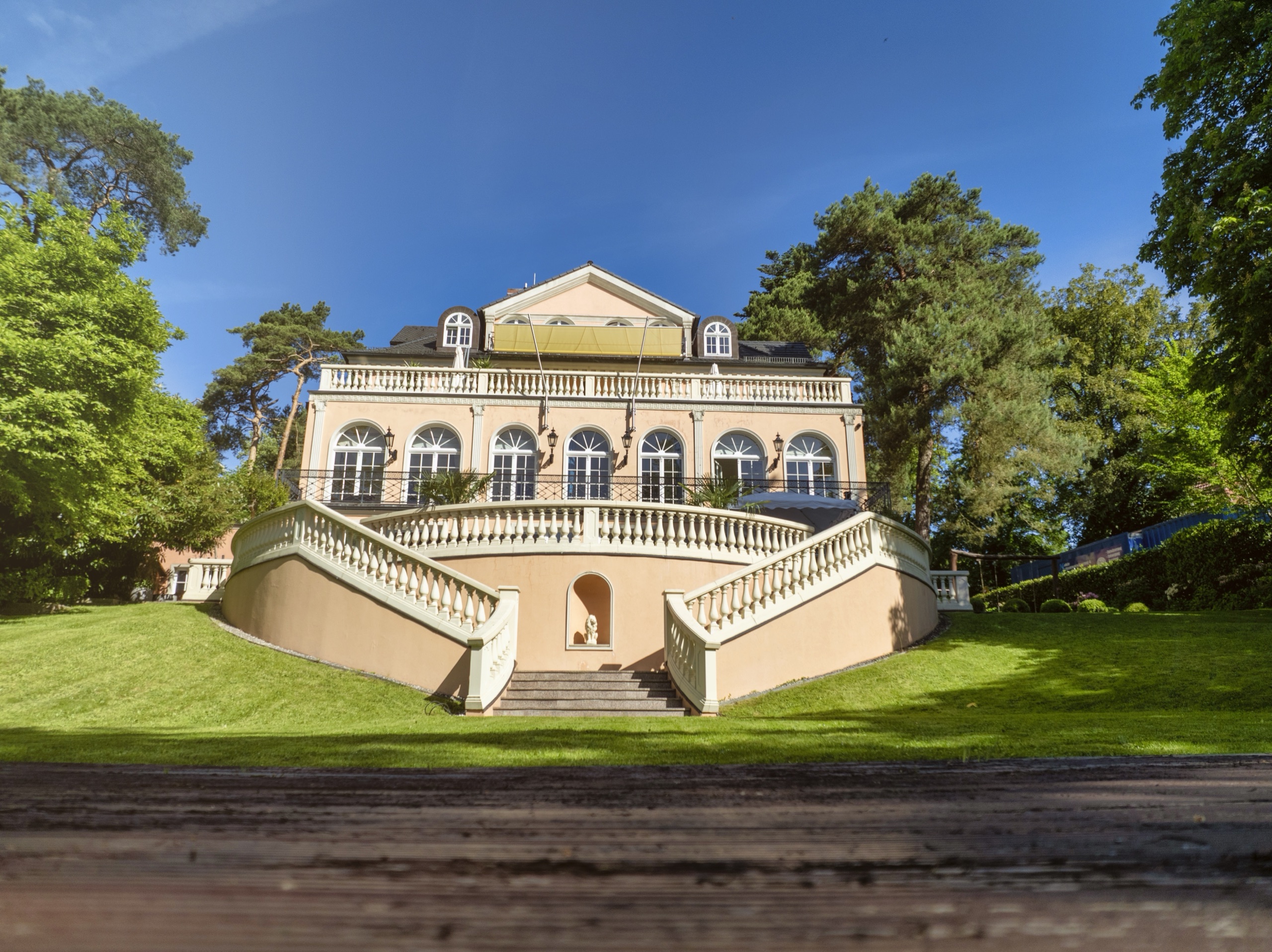 Herrschaftliche Villa im Grünen mit Freitreppe und Sonnensegel auf der oberen Terrasse