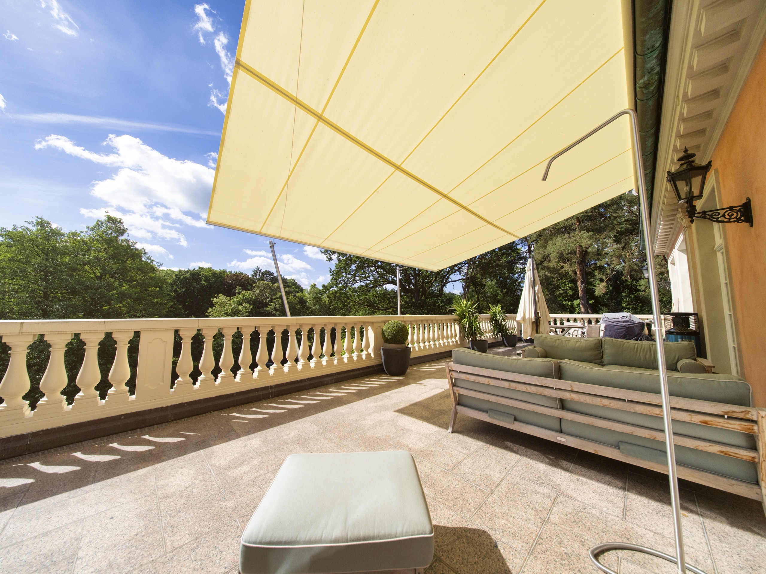 Lounge im Schatten des Sonnensegels auf der Villenterrasse